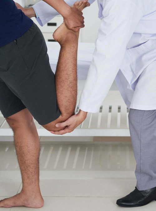 Cropped image of young man doing exercise with the therapist