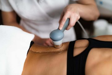 Ultrasound in Physical Therapy. Therapist Using Ultrasound Applicator on a Patient’s Lower Back